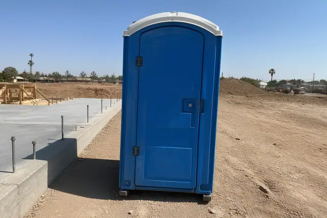 Blue portable toilet at a construction site in Glendale, AZ.