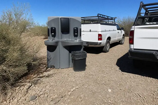 Dual handwashing station and service vehicles on a gravel construction site in Phoenix, AZ.