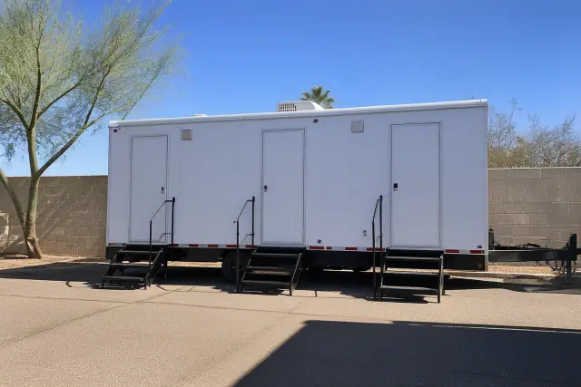 Luxury restroom trailer for event sanitation parked on an asphalt lot in Phoenix, AZ.