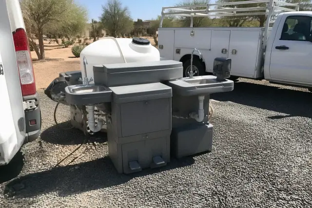 Dual handwashing station with plumbing installed on a gravel worksite in Phoenix, AZ.