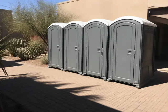 Portable toilets arranged on a paver patio at an outdoor event venue in Phoenix, AZ.