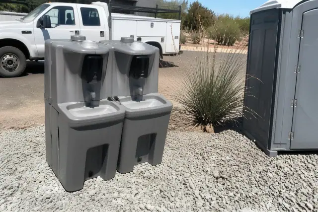 Portable handwashing station on a crushed stone surface at a construction site in Phoenix, AZ.