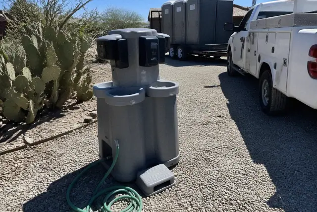 Portable handwashing station on a gravel lot with desert landscaping in Scottsdale, AZ.
