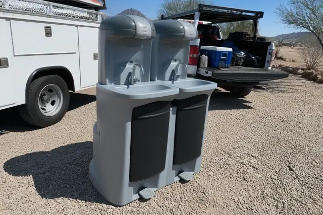 Dual handwashing station on a crushed stone surface at a worksite in Phoenix, AZ.