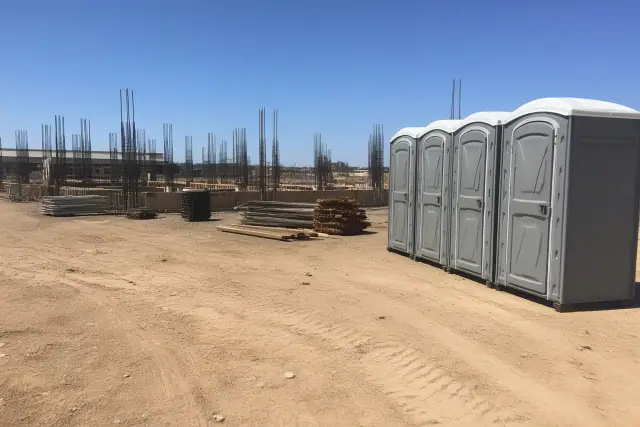 Multiple portable toilets for construction workers on a desert jobsite in Phoenix, AZ.