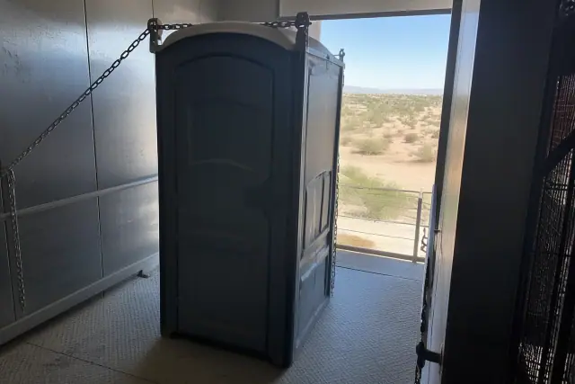 Portable restroom unit secured inside an industrial service elevator at a construction site in Buckeye, AZ.