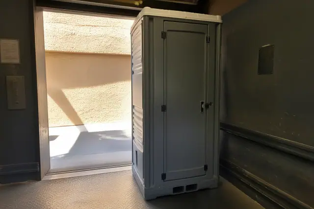 A narrow-profile portable restroom unit for construction crews inside a building in Phoenix, AZ.