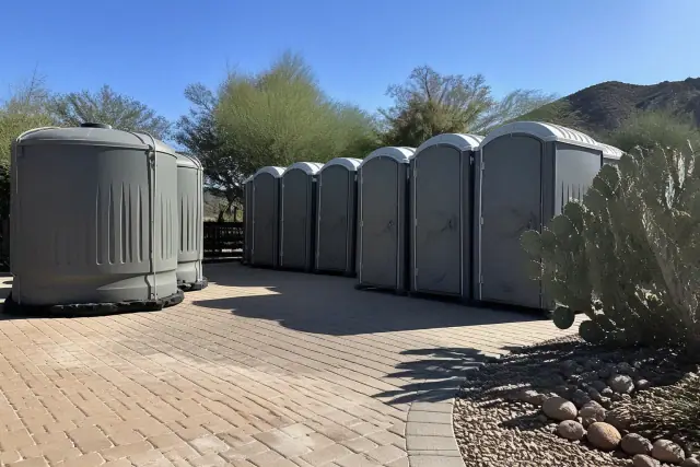 Portable toilets and holding tanks on a paver patio with desert landscaping in Phoenix, AZ.