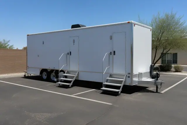 A luxury portable restroom trailer placed on an asphalt jobsite in Phoenix, AZ.