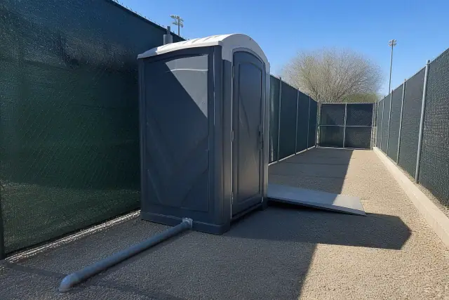 ADA-compliant portable toilet with ramp on desert gravel in Surprise, AZ.