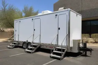 Stainless steel stairs leading to a luxury restroom trailer on a marked asphalt lot in Phoenix, AZ.