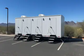 Portable shower trailer on a paved asphalt parking lot with distant mountain views in Phoenix, AZ.