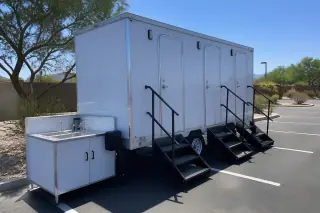 Luxury restroom trailer on a marked asphalt parking lot with desert landscaping in Phoenix, AZ.