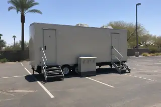 Luxury restroom trailer with integrated sinks parked on a faded asphalt lot in Phoenix, AZ.