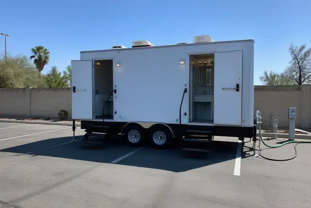 Luxury restroom trailer with running water and private suites parked on an asphalt lot in Phoenix, AZ.