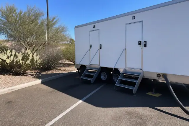 Luxury restroom trailer parked on asphalt with desert landscaping in Phoenix, AZ.