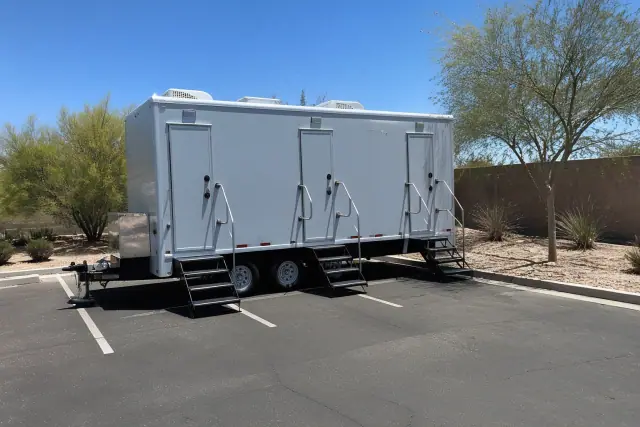Luxury restroom and shower trailer parked on an asphalt lot in Phoenix, AZ.