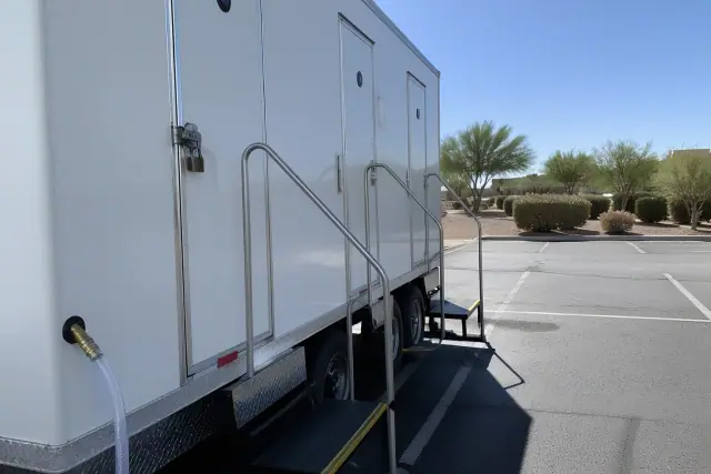 Luxury restroom trailer parked on an asphalt lot in Scottsdale, AZ.