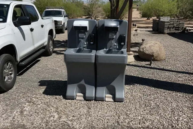 Dual foot-pump handwashing station on a crushed stone surface at a jobsite in Phoenix, AZ.