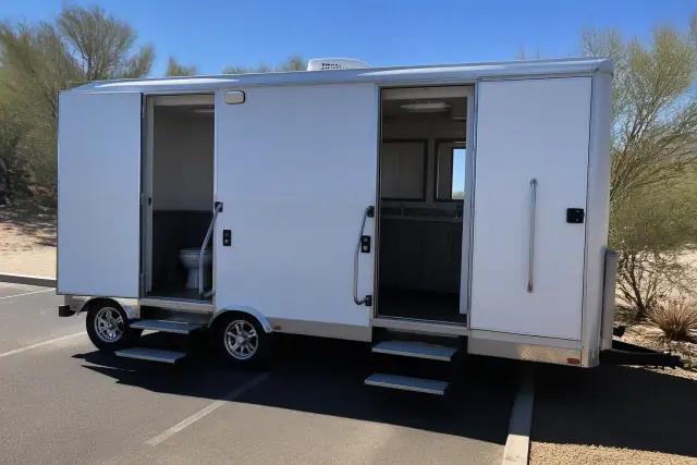 Luxury restroom trailer parked on an asphalt lot with desert landscaping in Phoenix, AZ.