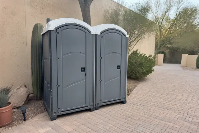 Two portable toilets placed on a paver patio for an outdoor event in Phoenix, AZ.
