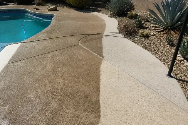Half-cleaned concrete pool deck with agave landscaping in a sunny backyard in Phoenix, AZ.
