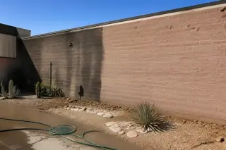 Cleaned masonry brick wall showing a diagonal line between dirty and restored sections at a Phoenix, AZ commercial site.