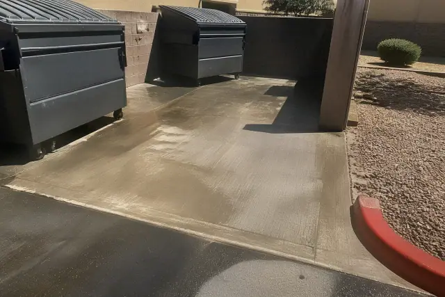 A clean concrete dumpster pad after grease removal at a business in Phoenix, AZ.