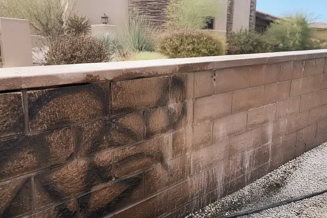 Brick wall undergoing graffiti and stain removal in Scottsdale, AZ.