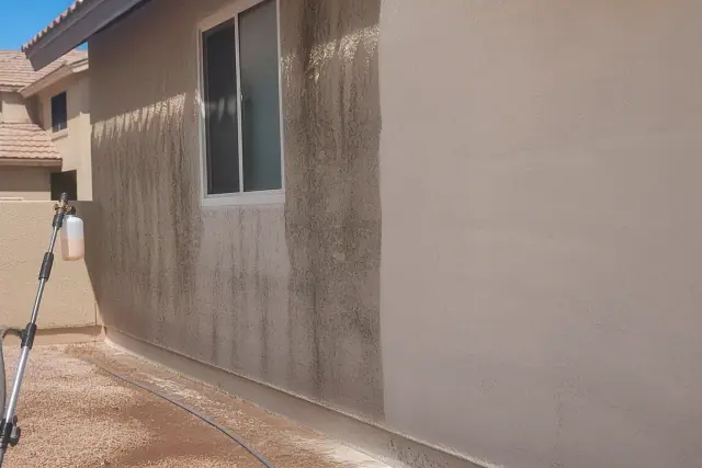 A stucco house in Chandler, AZ showing the contrast between dirty and clean siding during a soft washing service.