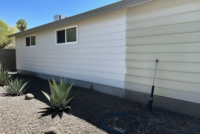 Soft wash cleaning on residential siding with desert landscaping in Tempe, AZ.