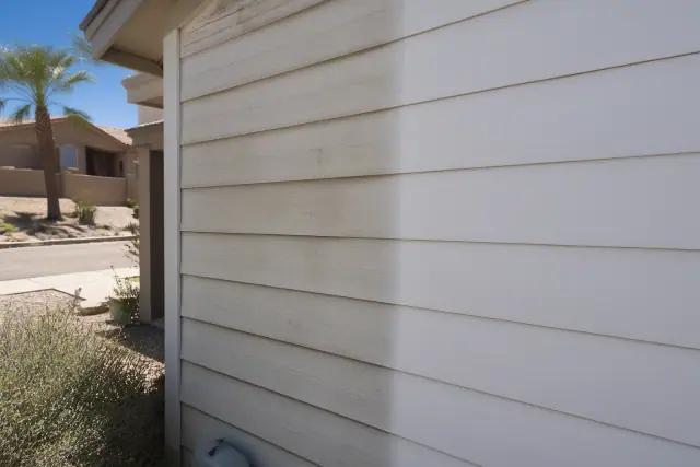 Residential house washing project showing clean and mildew-covered siding on a stucco home in Phoenix, AZ.