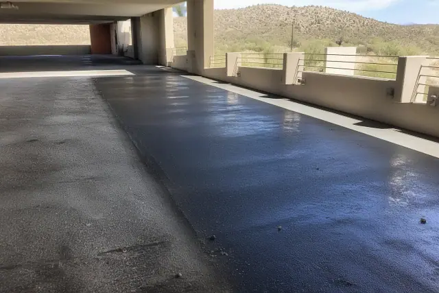 Cleaned asphalt surface in a multi-level parking garage in Phoenix, AZ, showing removed oil and tire marks.