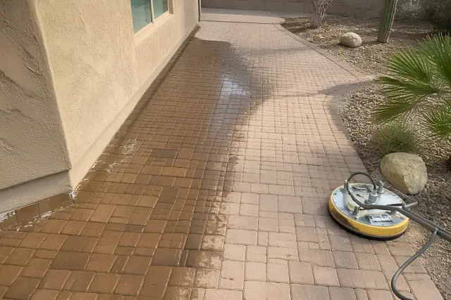 Professional cleaning of an interlocking stone paver walkway in Phoenix, AZ, showing wet patches during the process.