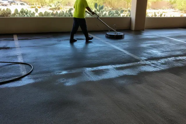 Pressure washing removing oil stains from asphalt in a parking garage in Scottsdale, AZ.