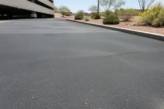 Cleaned asphalt pavement in a parking garage with volcanic rock landscaping in Phoenix, AZ.
