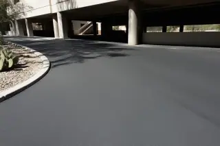 Cleaned asphalt parking garage surface with prickly pear cacti in the sunlight in Phoenix, AZ.
