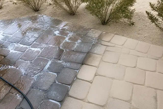 Technician cleaning and sealing stone pavers on a residential walkway in Buckeye, AZ.