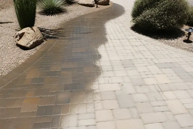 Stone paver walkway in Chandler, AZ showing a contrast between sealed and unsealed tiles during a cleaning service.