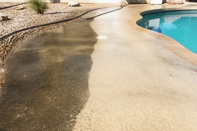 Pressure washing progress on a residential pool deck in Buckeye, AZ showing clean versus stained concrete.