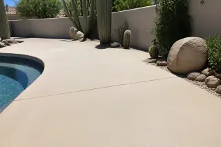 Cleaned non-slip concrete pool deck with saguaro cacti and tan stucco walls in Phoenix, AZ.