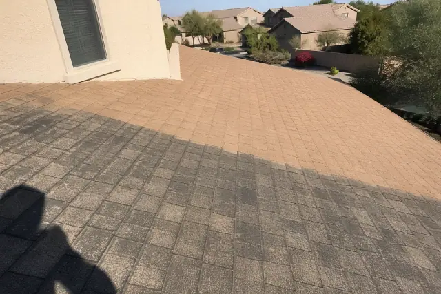 Asphalt shingle roof in Phoenix, AZ showing the difference between black algae streaks and cleaned shingles.