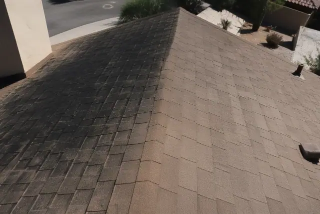 Asphalt shingle roof in Phoenix, AZ, showing the contrast between black algae streaks and cleaned sections.