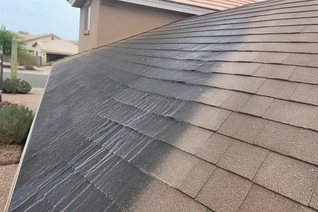 A residential roof in Peoria, AZ showing the contrast between cleaned shingles and black algae streaks.