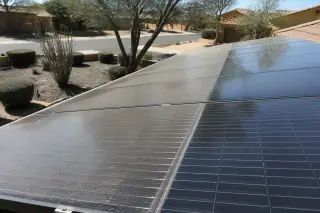 Cleaned solar panels showing a clear divide between dusty and shiny sections in Phoenix, AZ.