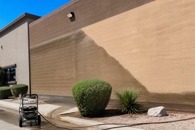 Commercial pressure washing in progress on a brick building facade in Phoenix, AZ.