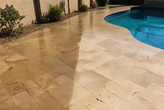 Travertine soft washing on a pool deck showing cleaned and stained sections at a residence in Phoenix, AZ.