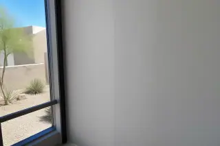 Smooth, paint-ready drywall seam transition with desert landscape visible through a window in Phoenix, AZ.