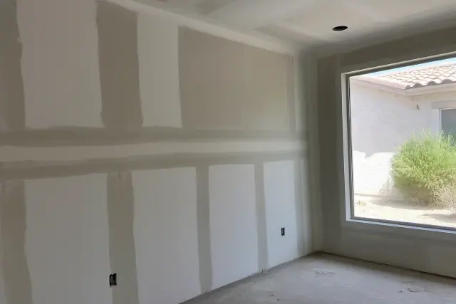 Drywall joints with wet paper tape and gray compound at a construction site in Phoenix, AZ.
