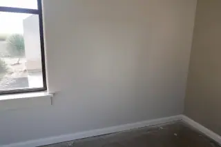 Seamlessly blended drywall patch on an interior wall with a desert landscape view in Phoenix, AZ.